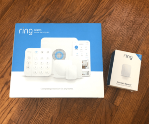 Ring Alarm Home Security 8-piece Kit (2nd Gen) and Contact Sensor box on a wooden floor.