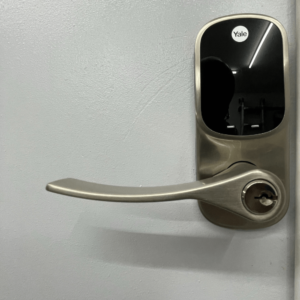 Close-up of a Yale smart lock with touchscreen keypad and handle installed on a door.